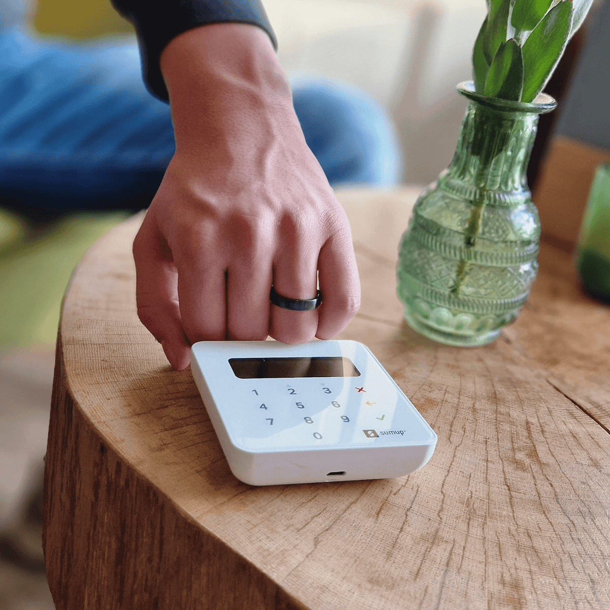 Person using a contactless payment ring on a payment terminal, showcasing 2 in 1 payment wearables.