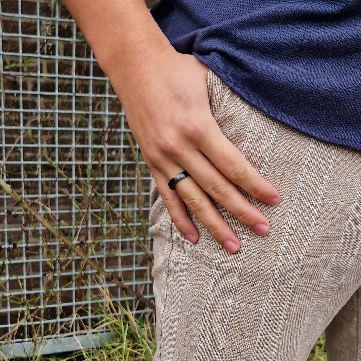 Ein Astari x Bybit kontaktloser Zahlungsring an der Hand, der sein elegantes Design und seine einfache Bedienbarkeit hervorhebt, bildet einen schönen Kontrast zu einem lässigen Outfit.